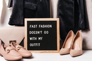 Neutral clothes with letterboard sign that reads: Fast fashion doesn't go with my outfit. 