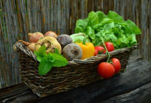 Basket of beautiful fresh produce: lettuce, tomato, bell pepper, beets, and other root vegetables. 